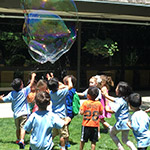 kids playing outside catching bubbles